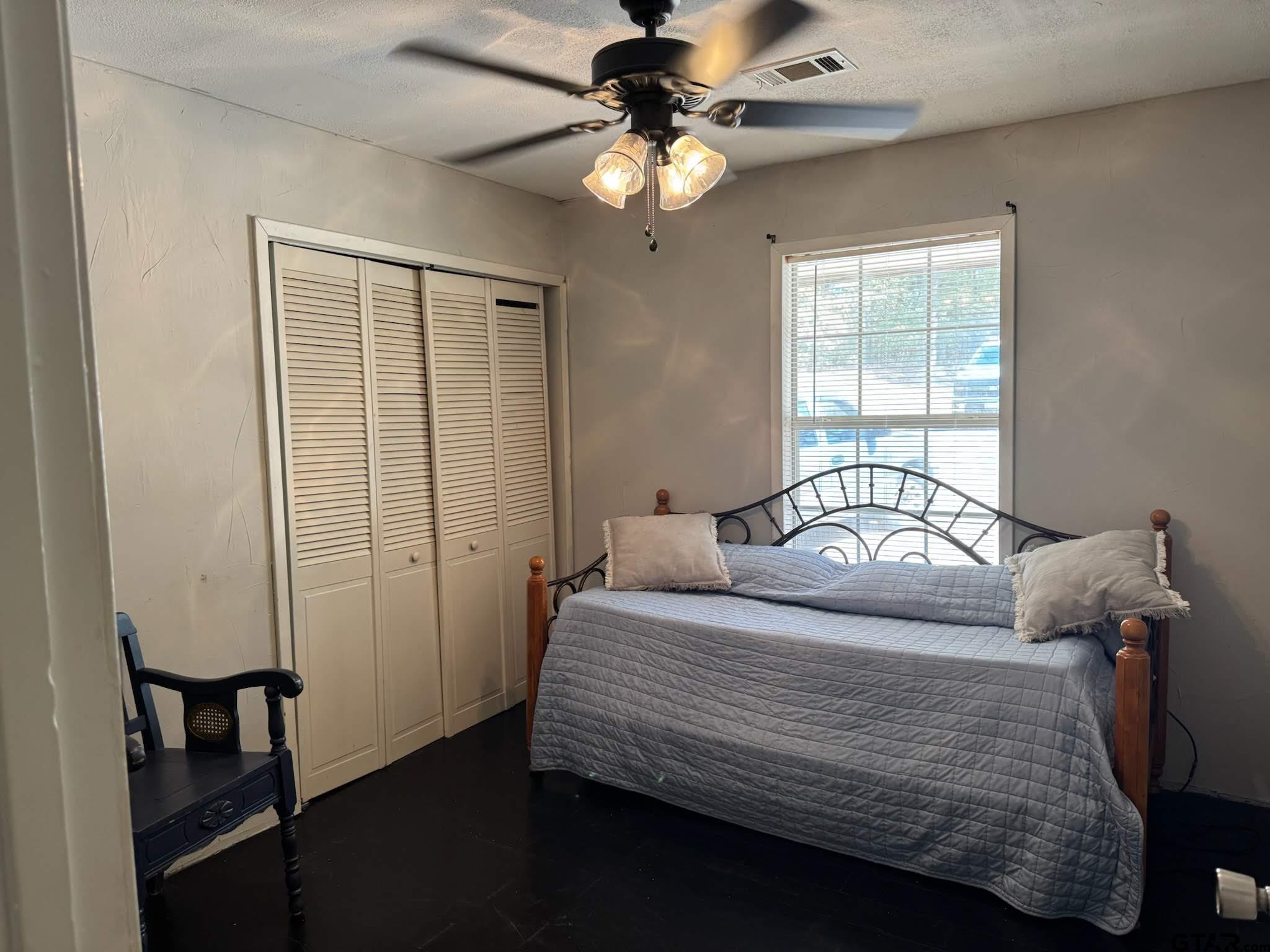 14032 Eastside Road Tyler, TX 75707 - Photo 26 of 36 a bedroom with a bed and a chandelier