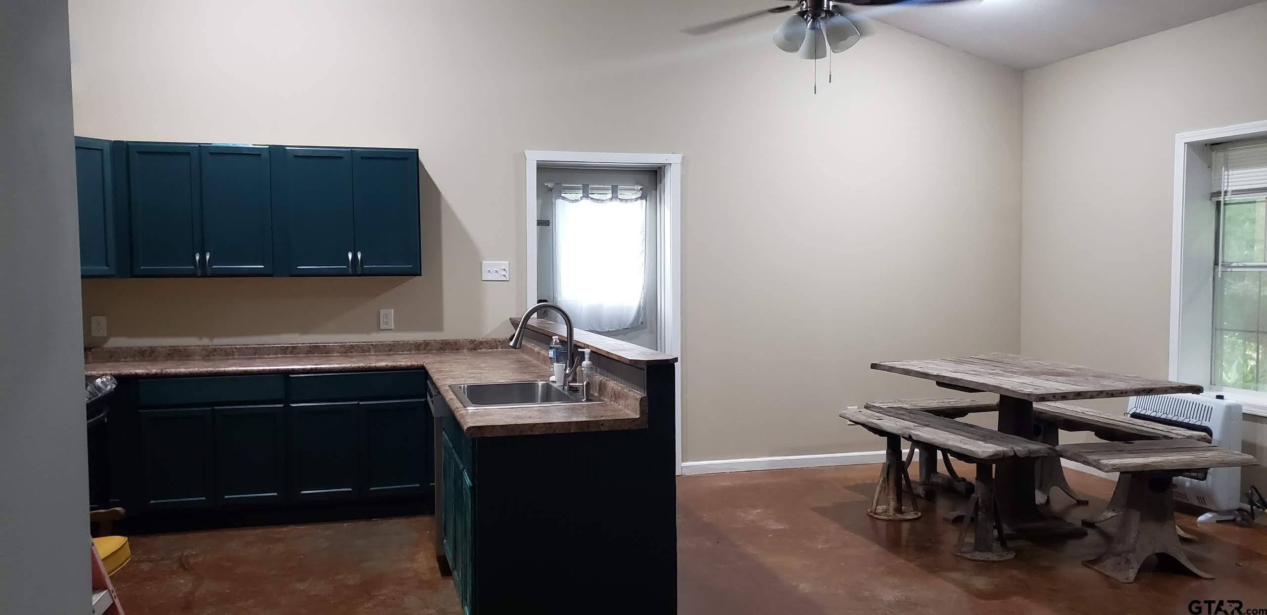 14032 Eastside Road Tyler, TX 75707 - Photo 31 of 36 a kitchen with a sink cabinets and a stove top oven