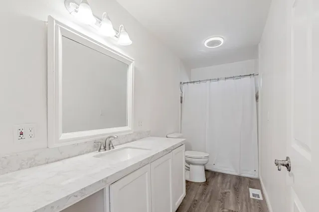 a bedroom with a large bed and a flat tv screen on dresser