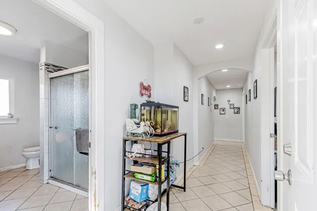 a living room with stainless steel appliances furniture and a kitchen view