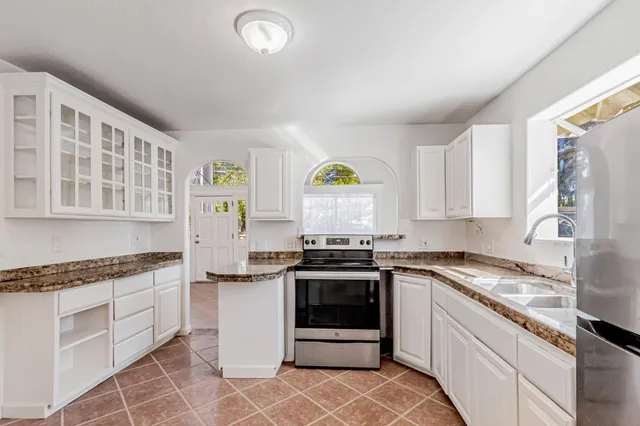 a kitchen with stainless steel appliances granite countertop a sink stove and refrigerator