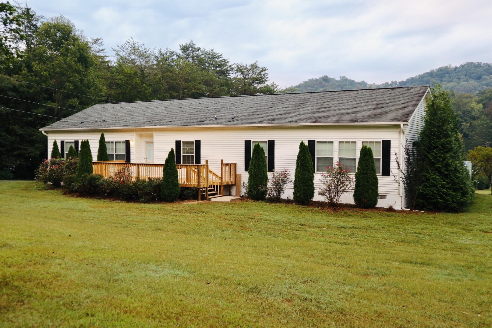 a view of a house with floor to ceiling windows and yard