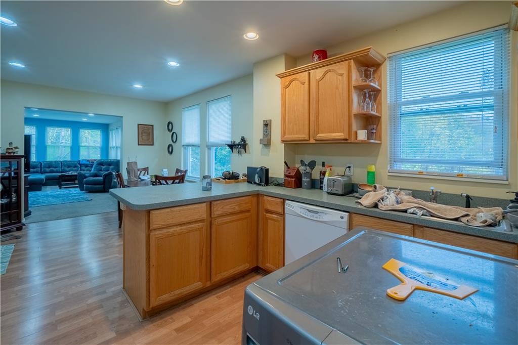 5407 Verona Road Verona, PA 15147 - Photo 7 of 25 a kitchen with stainless steel appliances granite countertop a sink dishwasher stove and cabinets with wooden floor