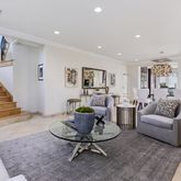 a living room with furniture and a dining table with wooden floor