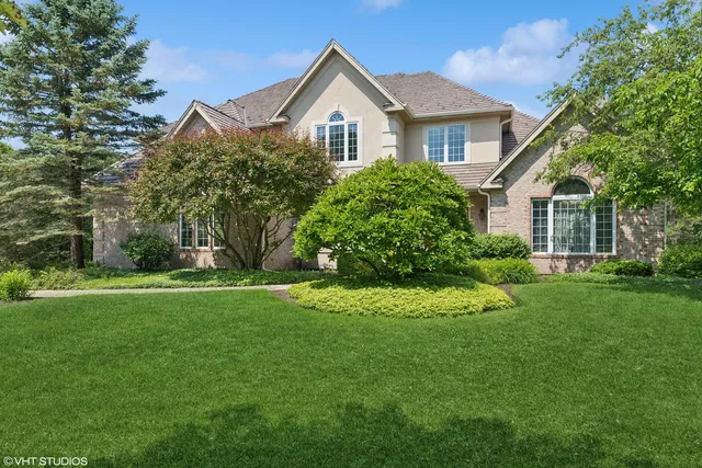 a front view of a house with a yard and trees
