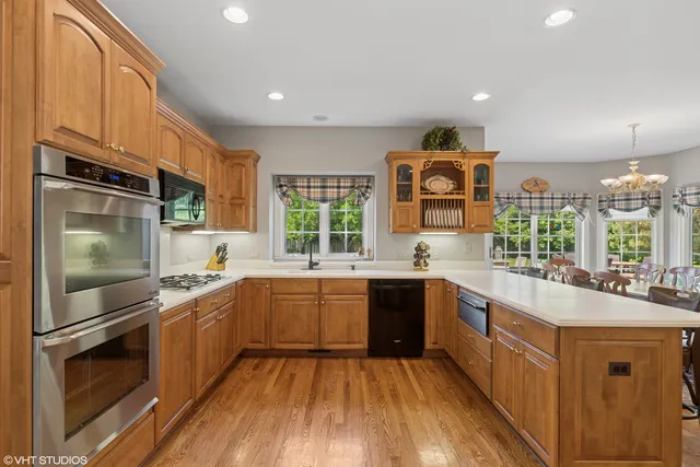 a large kitchen with stainless steel appliances granite countertop a stove and a sink