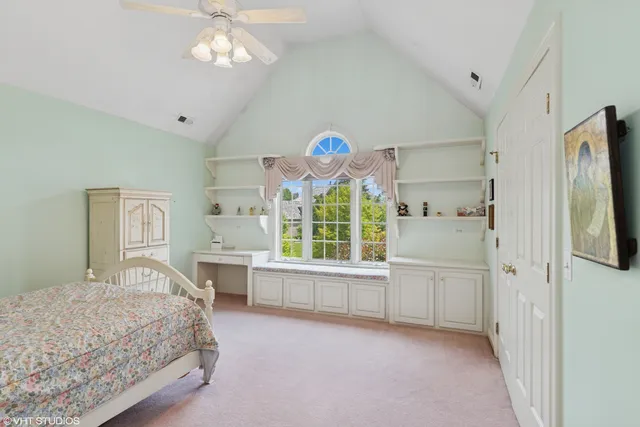 a spacious bedroom with a bed and a chandelier