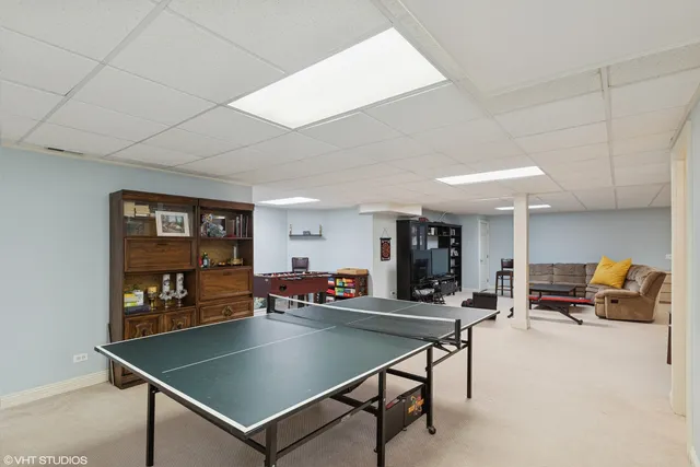 a living room with furniture a table tennis and a ceiling fan