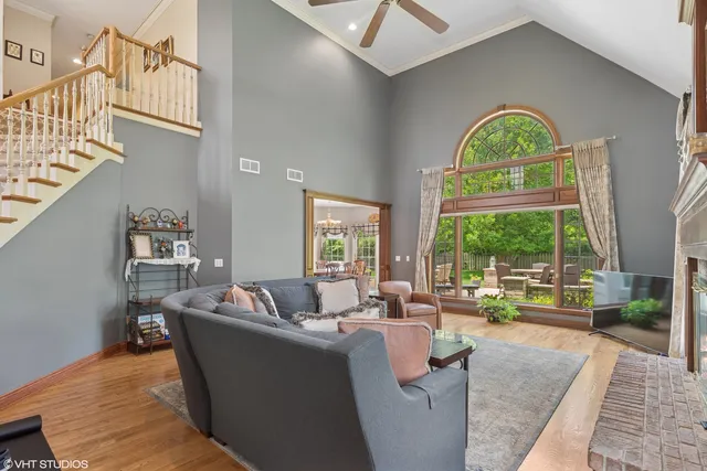 a living room with fireplace furniture and a large window