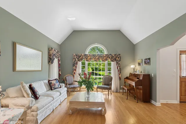 a living room with furniture floor to ceiling window and wooden floor