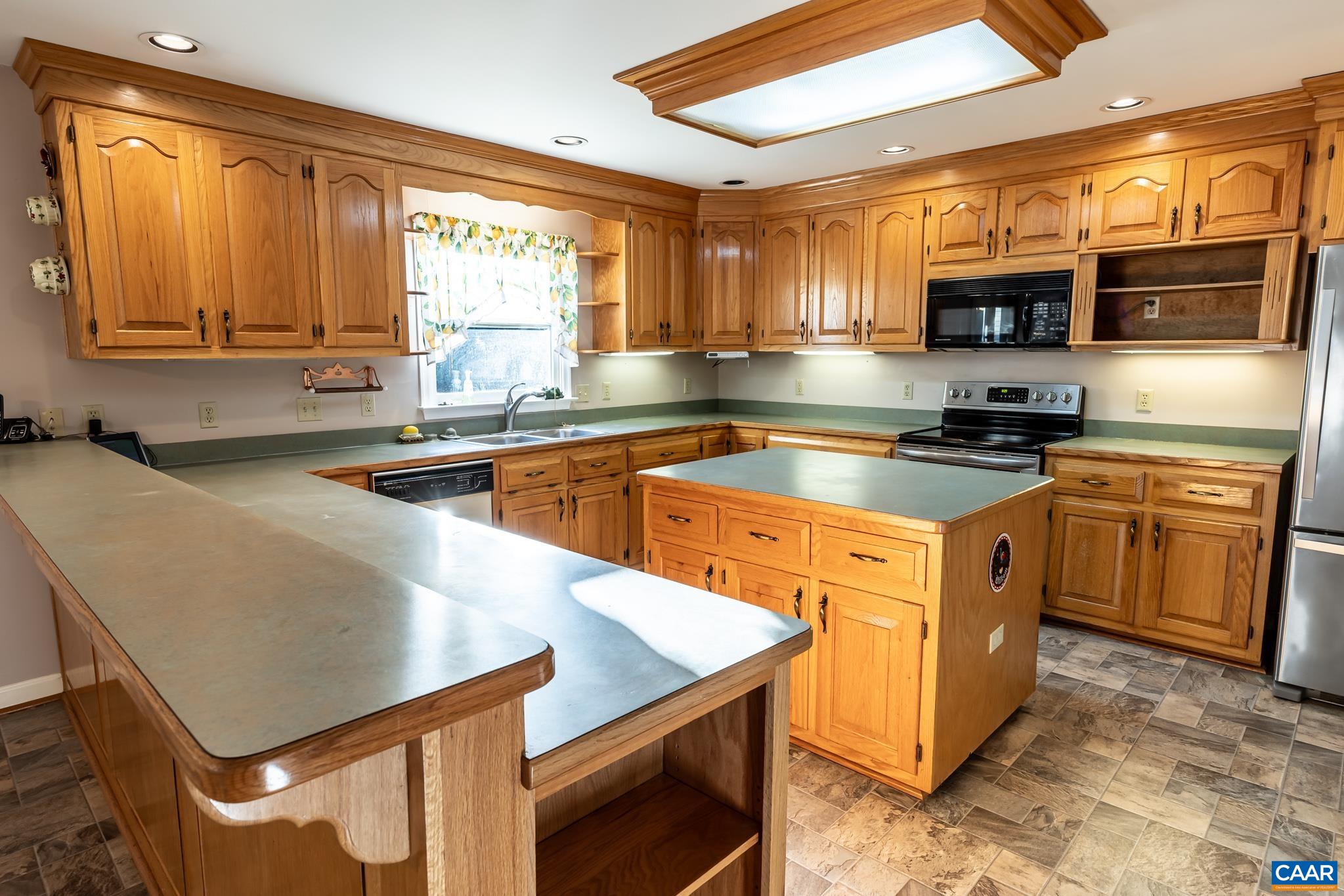 208 Rolling Hills Road Ruckersville, VA 22968 - Photo 10 of 56 a kitchen with stainless steel appliances granite countertop a sink stove and microwave