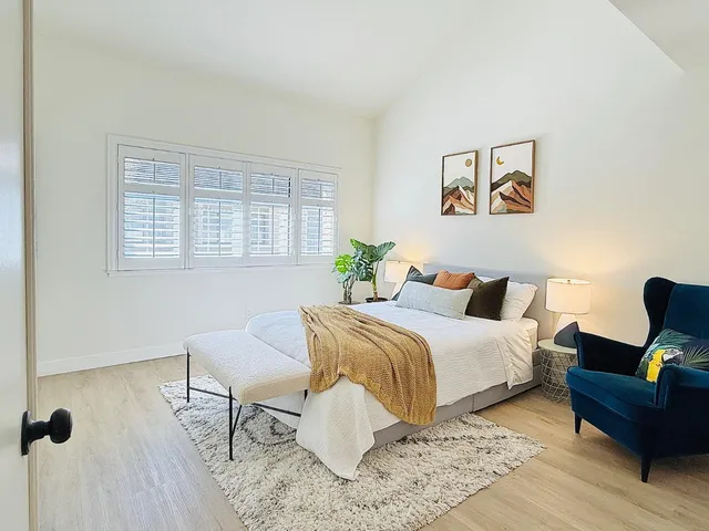 a bedroom with a bed and wooden floor