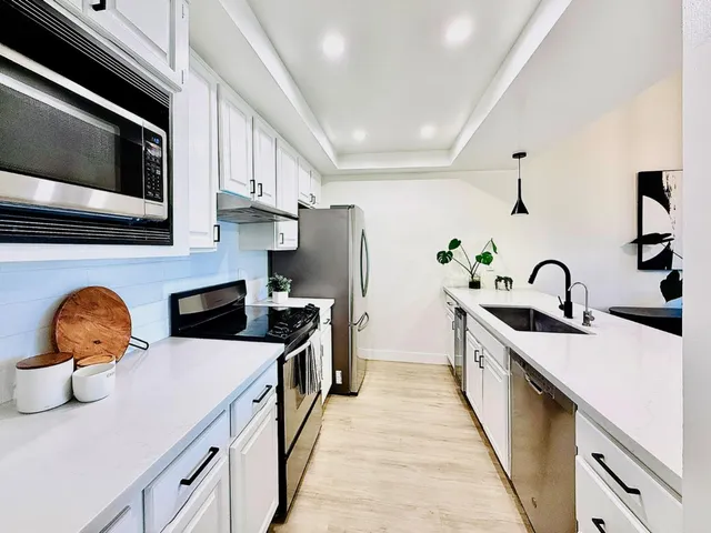a kitchen with stainless steel appliances granite countertop a sink and stove