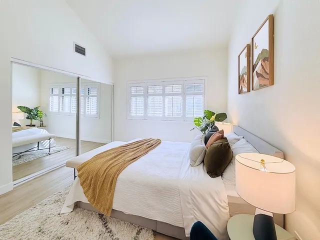 a bedroom with a bed and a potted plant