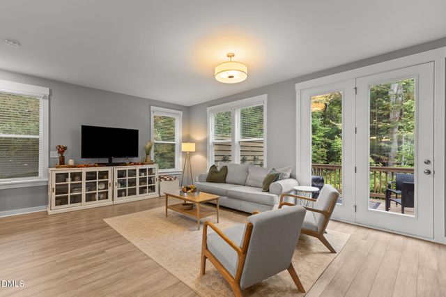 a kitchen with stainless steel appliances granite countertop a stove top oven a sink dishwasher a dining table and chairs with wooden floor