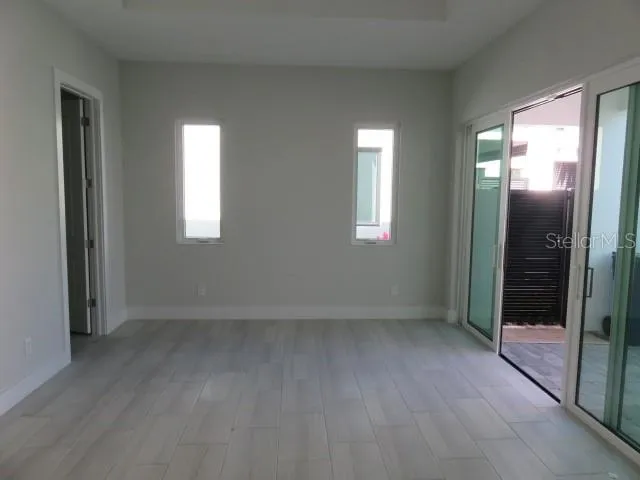 a view of an empty room with glass door and a window
