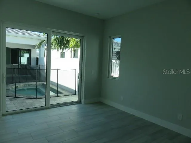 an empty room with wooden floor and a fireplace