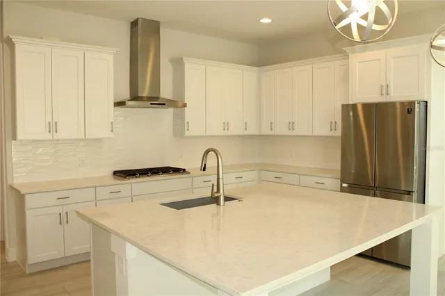 a kitchen with stainless steel appliances granite countertop a sink a refrigerator and a stove