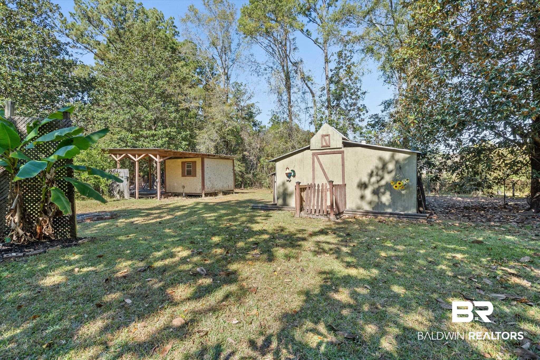 180 Creax Road Axis, AL 36505 - Photo 29 of 35 View of green lawn with a storage unit and a patio