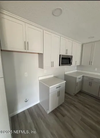 a kitchen with a sink a counter space and cabinets