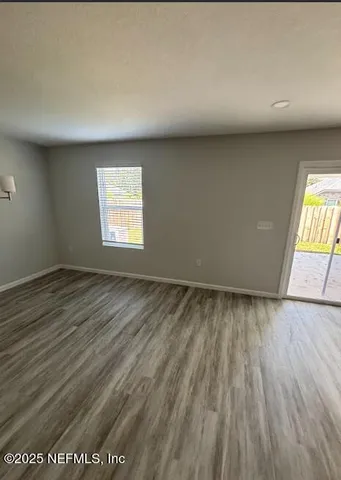 a view of a room with wooden floor and chandelier