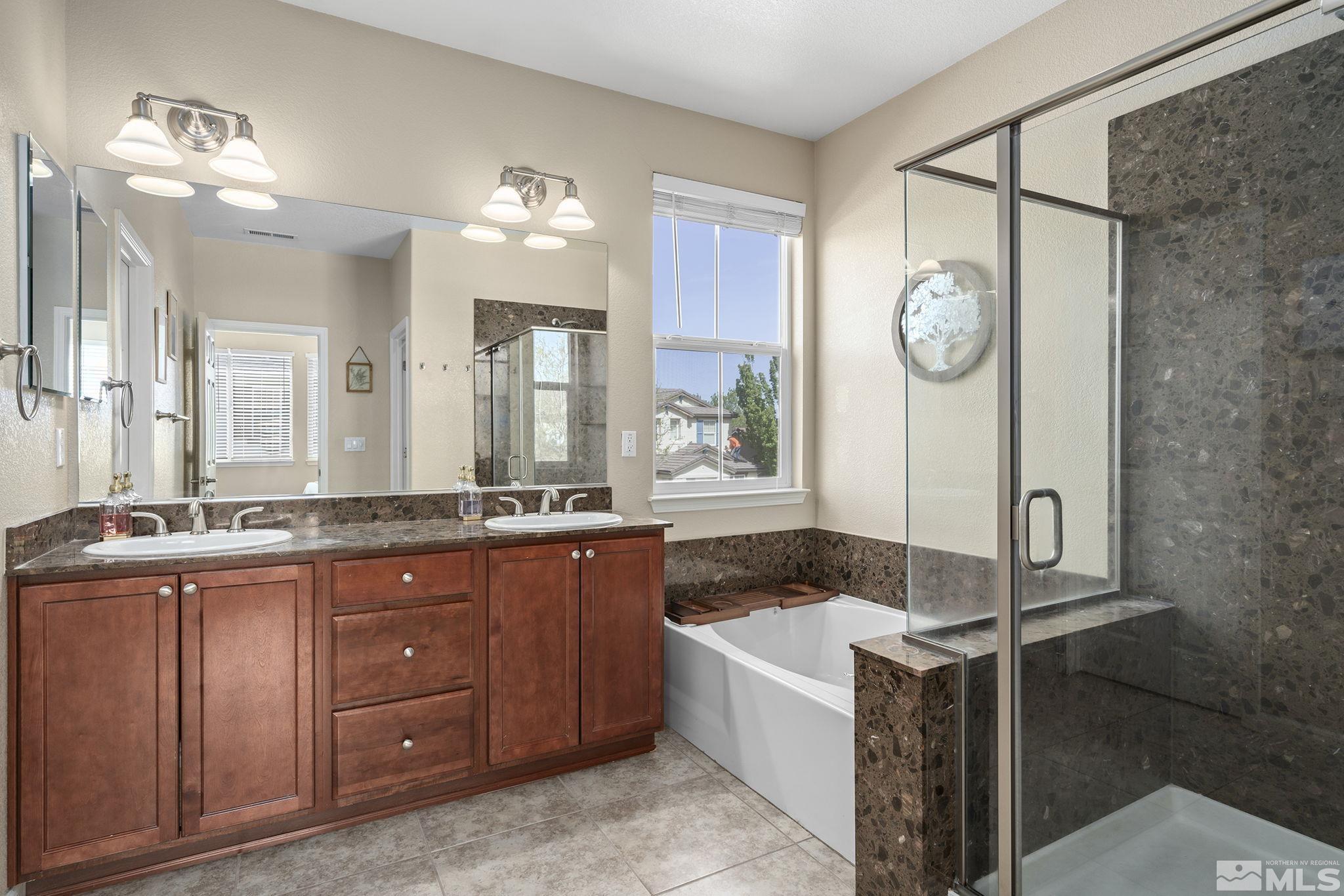 10854 Oakhaven Drive Reno, NV 89521 - Photo 17 of 38 a spacious bathroom with a granite countertop sink mirror and shower