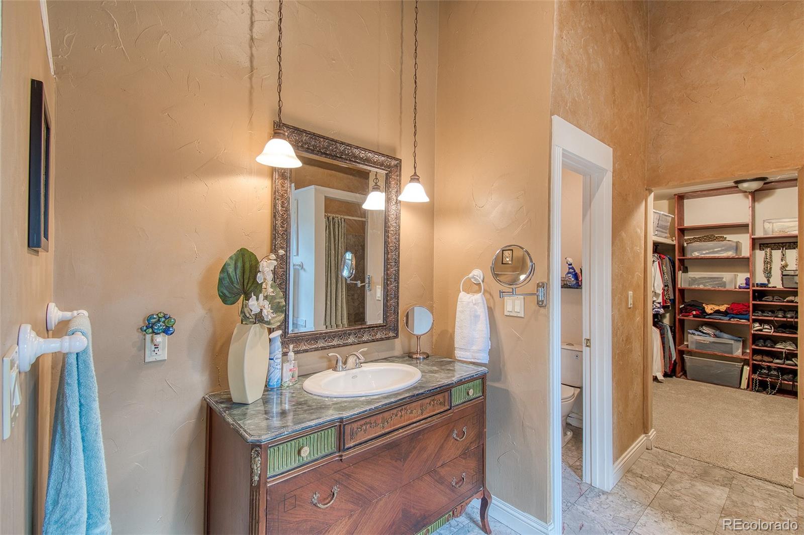 416 Conestoga Road Bailey, CO 80421 - Photo 18 of 40 a bathroom with a granite countertop sink a mirror and shower