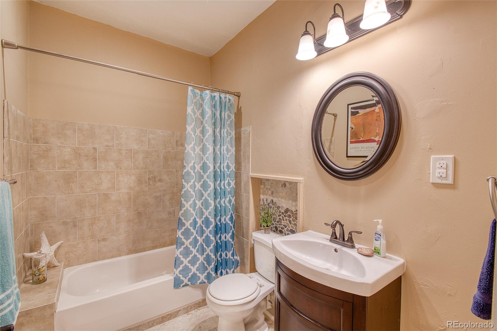 416 Conestoga Road Bailey, CO 80421 - Photo 21 of 40 a bathroom with a sink a mirror a toilet and a bathtub