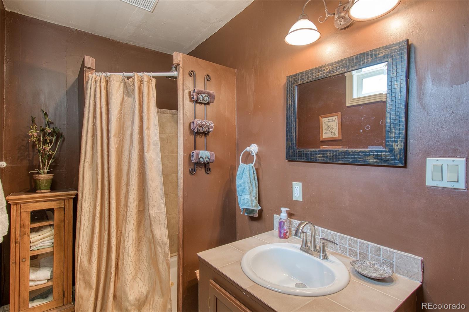 416 Conestoga Road Bailey, CO 80421 - Photo 24 of 40 a bathroom with a sink and a mirror