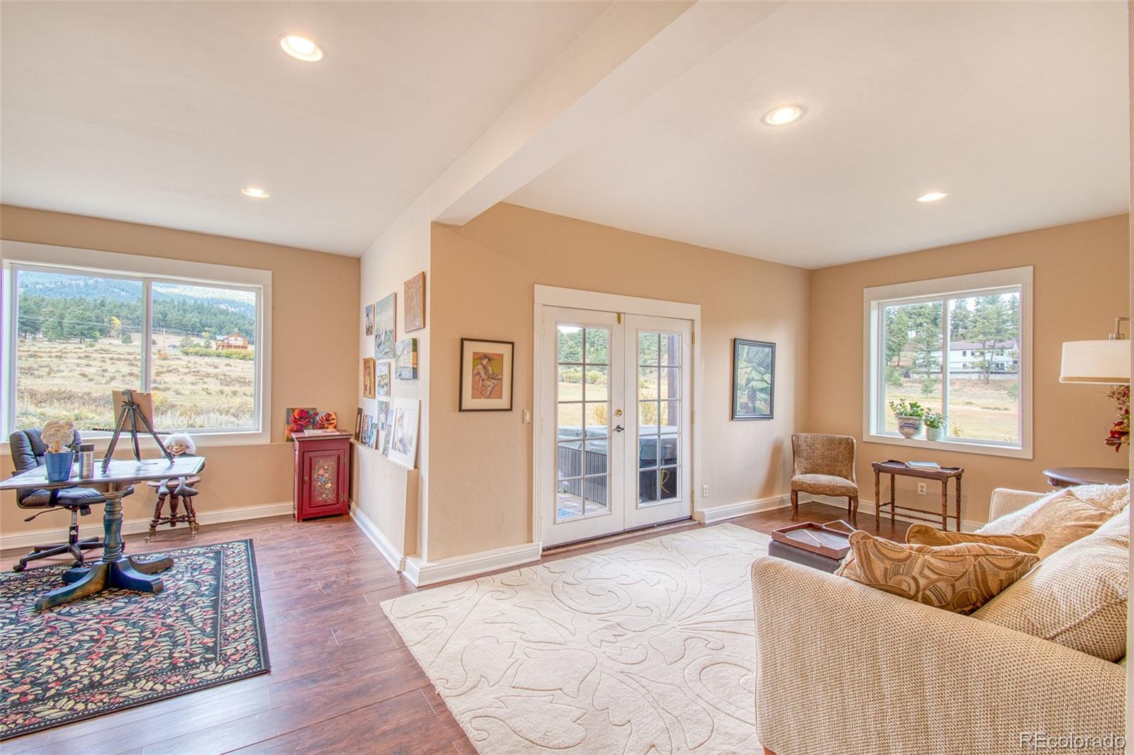416 Conestoga Road Bailey, CO 80421 - Photo 29 of 40 a living room with furniture and large windows with wooden floor