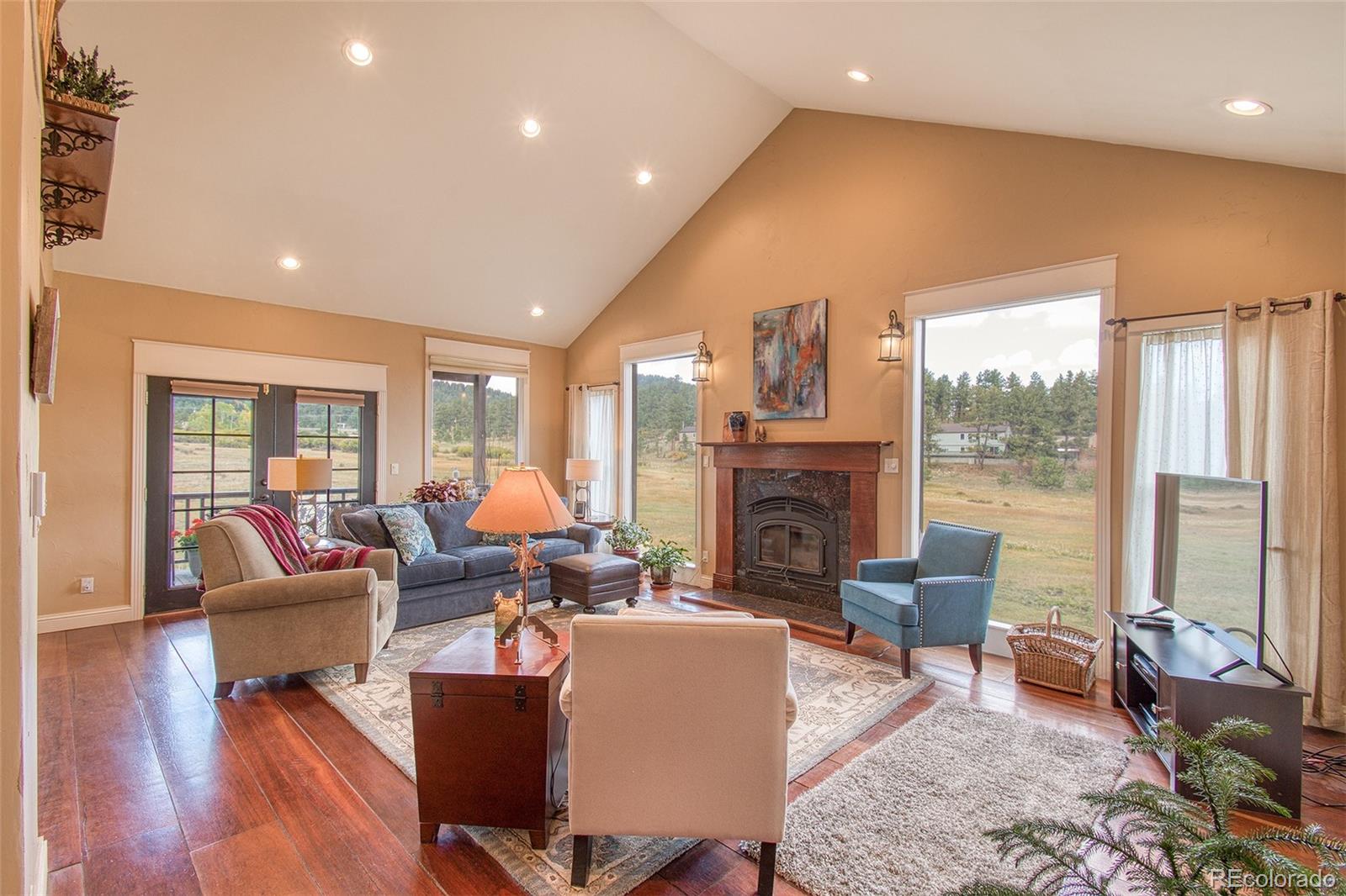 416 Conestoga Road Bailey, CO 80421 - Photo 7 of 40 a living room with fireplace furniture and a large window
