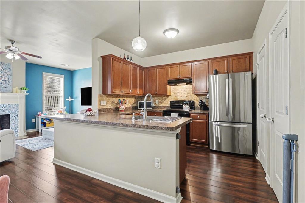 404 East Gate Trail Ball Ground, GA 30107 - Photo 9 of 25 a kitchen with stainless steel appliances granite countertop a refrigerator a sink dishwasher a stove with wooden floor and cabinets