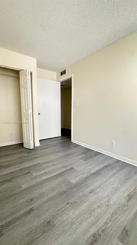 an empty room with wooden floor and closet
