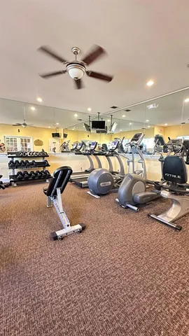 a room with lots of white furniture and a chandelier