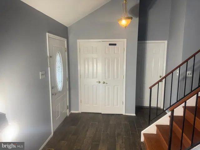 a view of a hallway with wooden floor and stairs