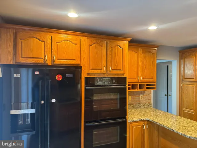 a kitchen with stainless steel appliances granite countertop a refrigerator and cabinets
