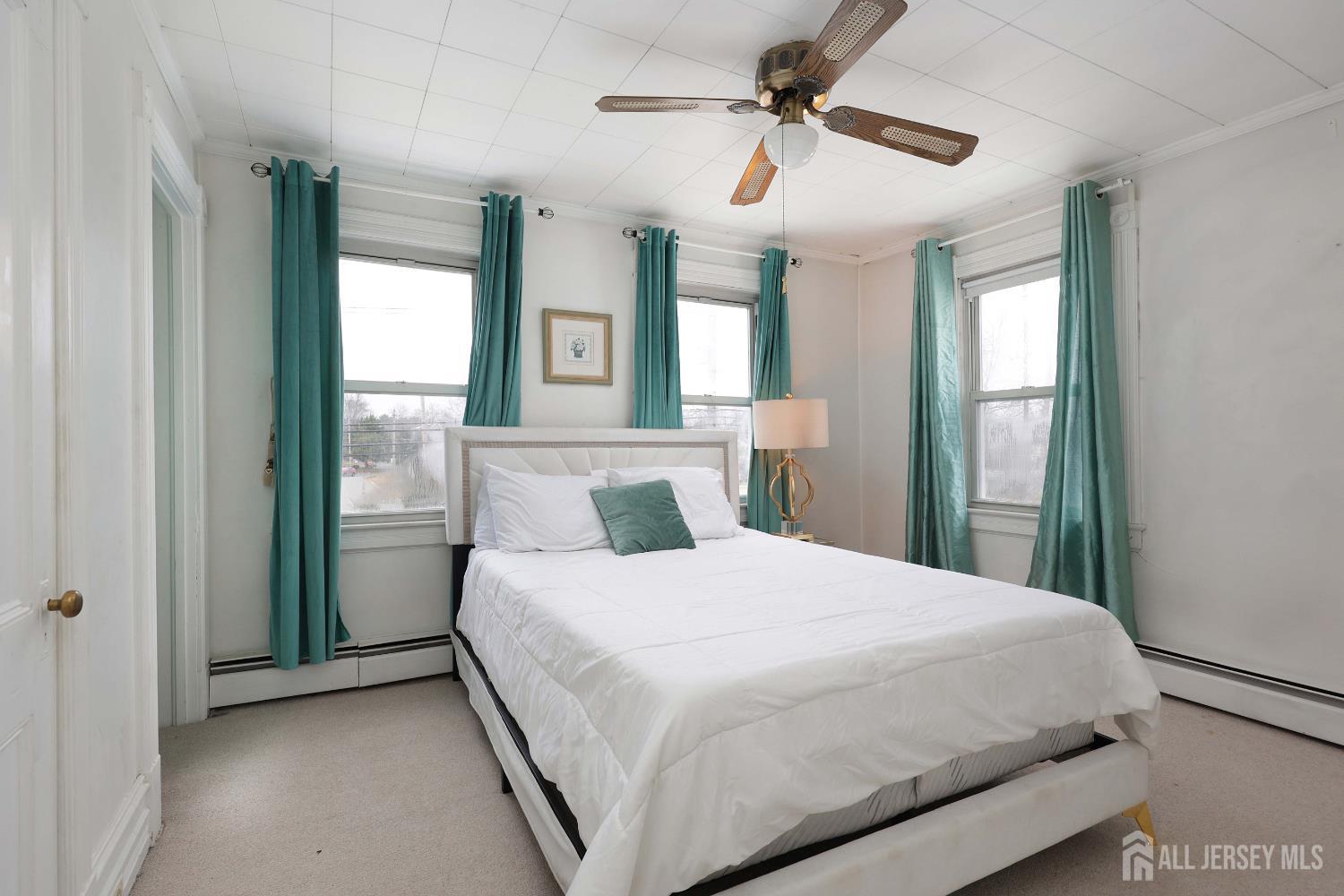 92 Main Street Helmetta, NJ 08828 - Photo 21 of 57 a bedroom with a large bed and a chandelier