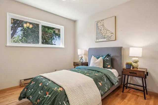 a bedroom with a bed and a lamp next to a window