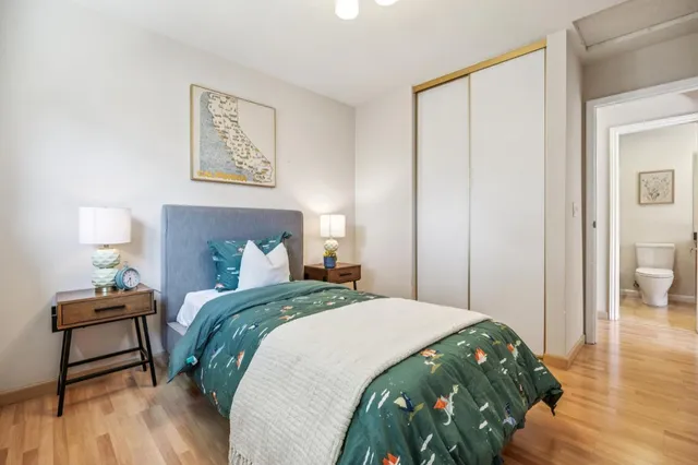 a bedroom with a bed and wooden floor