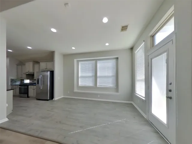 a view of kitchen with refrigerator and window