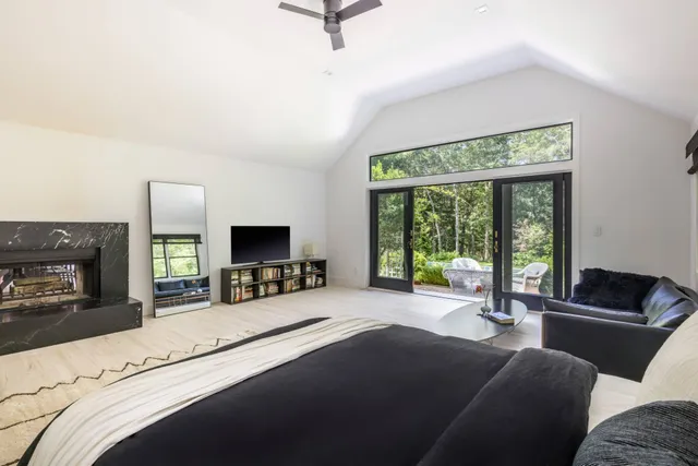a living room with furniture a flat screen tv and a large window