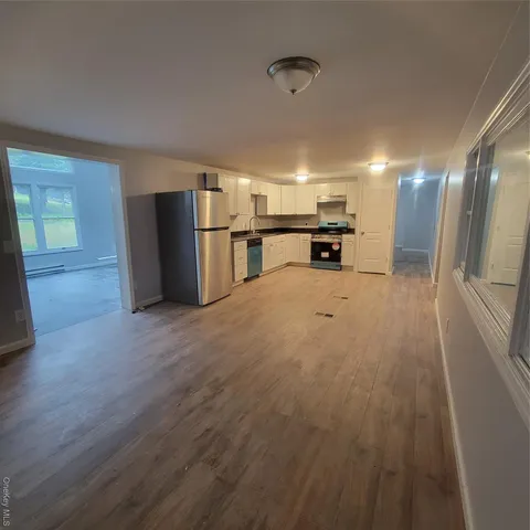 a view of a kitchen with a sink and a refrigerator