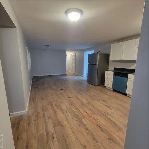 an empty room with wooden floor and fireplace