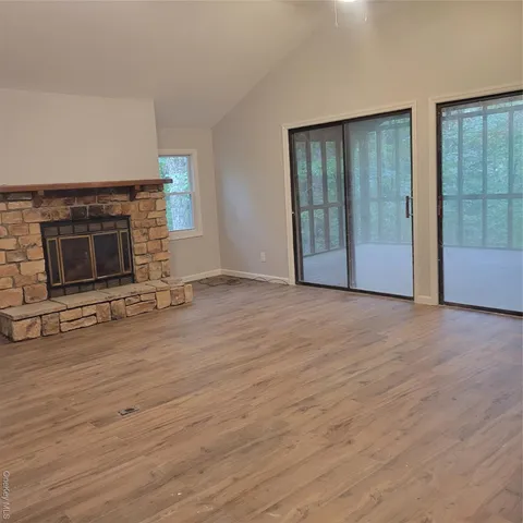 a view of an empty room with a fireplace and a window