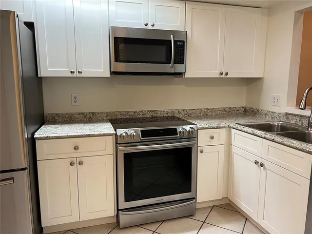 a kitchen with stainless steel appliances a stove a microwave and sink