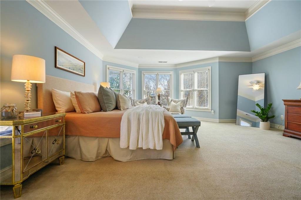 1260 Elk Ridge Cove Alpharetta, GA 30005 - Photo 31 of 87 a spacious bedroom with a bed and a lamp with the outer view