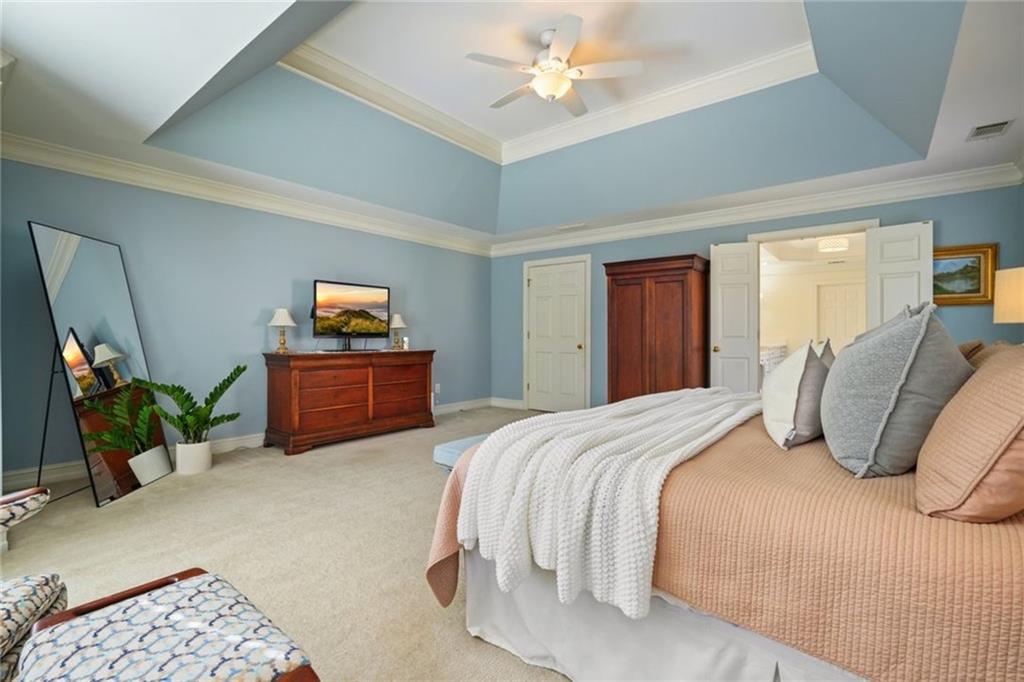 1260 Elk Ridge Cove Alpharetta, GA 30005 - Photo 32 of 87 a bedroom with a bed and a chandelier