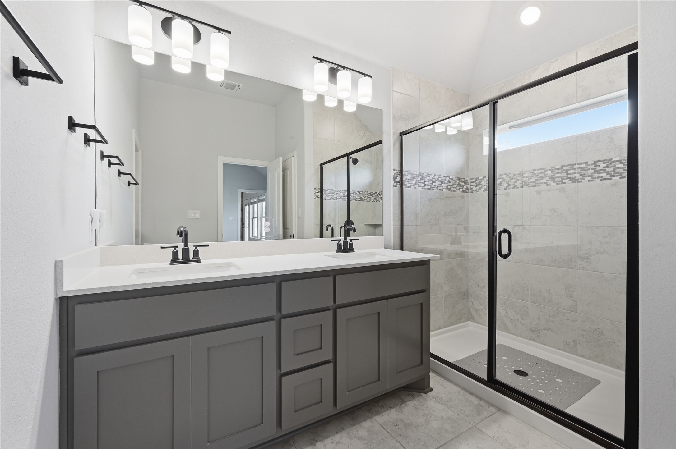 426 Cold Riv Run Kyle, TX 78640 - Photo 18 of 34 A well-appointed primary bathroom featuring a dual vanity with ample storage and a sleek glass-enclosed shower.
