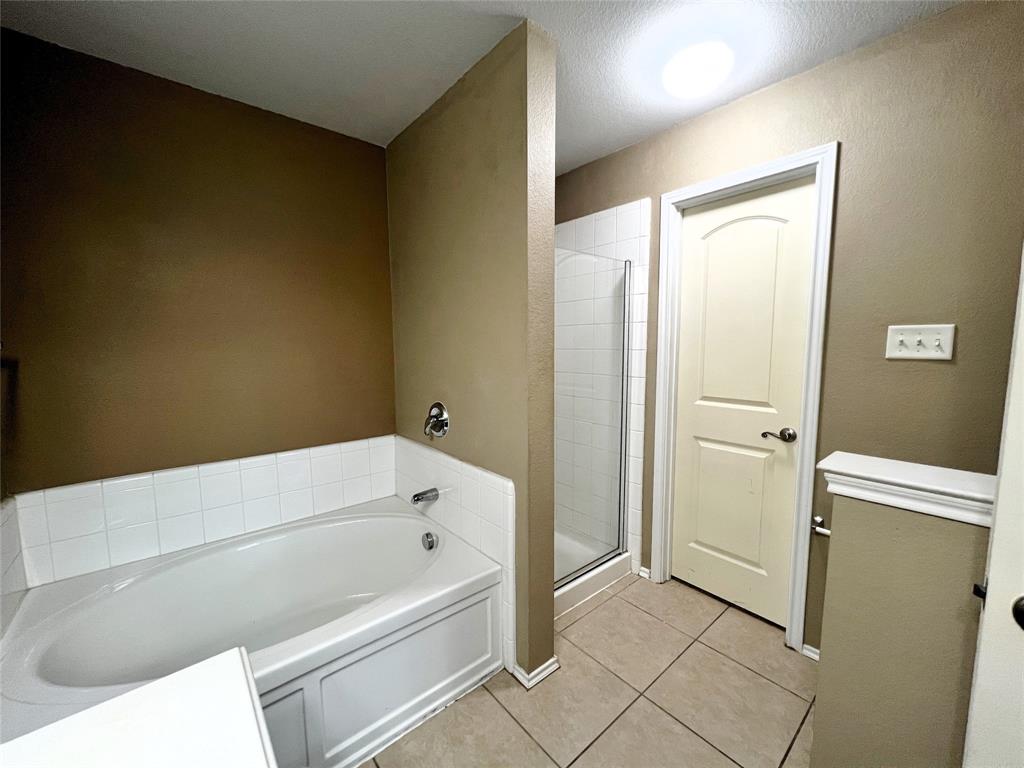 8813 Chisholm Trail Cross Roads, TX 76227 - Photo 13 of 24 a bathroom with a bathtub and a shower