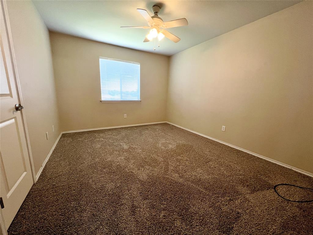 8813 Chisholm Trail Cross Roads, TX 76227 - Photo 19 of 24 an empty room with a ceiling fan and a window